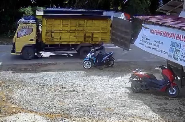 Motorcyclist knocked down after colliding with a truck’s open rear door - Indonesia